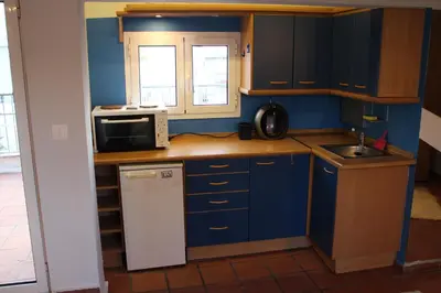 a small kitchen with blue cabinets and a microwave at Roof Top Studio in Athens