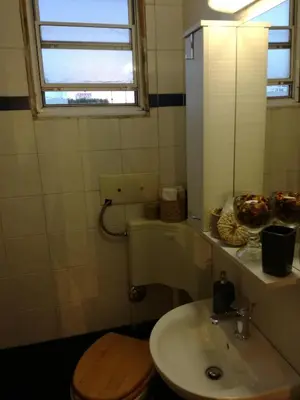 a bathroom with a sink and a toilet and a window at Roof Top Studio in Athens