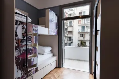 a room with a window and a room with a view of a building at Nubian Hostel in Athens