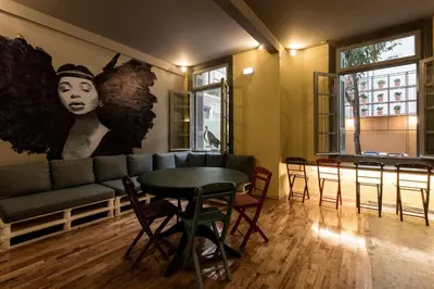 a living room with a couch and a table and chairs at Nubian Hostel in Athens