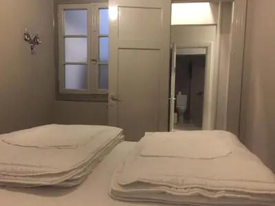 two beds in a room with a window and a mirror at Nubian Hostel in Athens