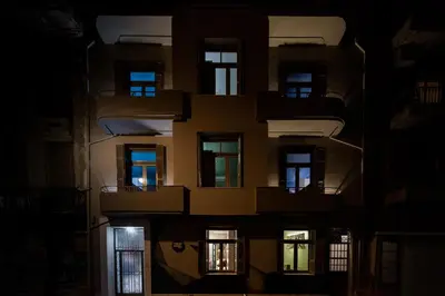 a tall building at night with lights in the windows at Nubian Hostel in Athens
