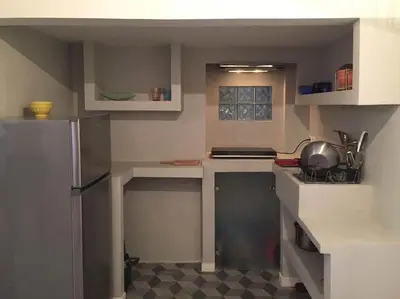 a small kitchen with a refrigerator and a stove at 5th floor bright flat at bohemian Exarcheia in Athens