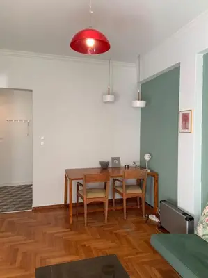 a dining room with a wooden table and chairs at 5th floor bright flat at bohemian Exarcheia in Athens