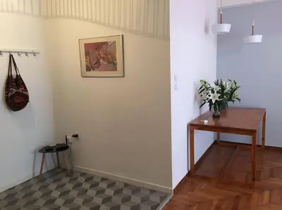 a room with a table and flowers on a wall at 5th floor bright flat at bohemian Exarcheia in Athens
