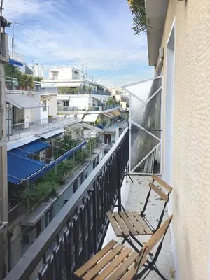 a balcony with a chair and a building at 5th floor bright flat at bohemian Exarcheia in Athens