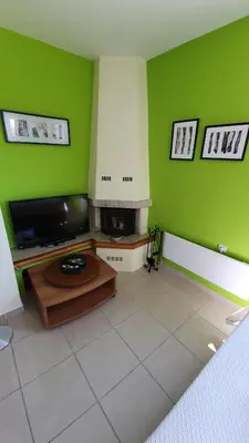 a living room with a tv and green walls at Acropolis at your fingertips in Athens