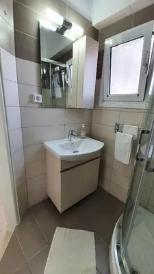 a bathroom with a sink and a mirror and a shower at Acropolis at your fingertips in Athens