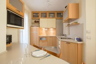 a kitchen with wooden cabinets and a dining table at Acropolis at your fingertips in Athens