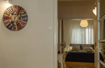 a bedroom with a clock on the wall next to a bed at Elite Downtown Central 5th Floor Apartment in Athens