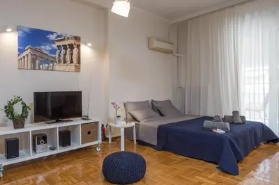 a bedroom with a bed and a flat screen tv at Elite Downtown Central 5th Floor Apartment in Athens