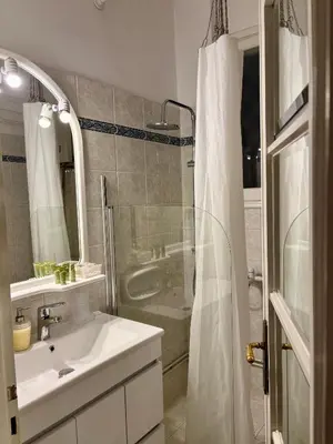 a white bathroom with a sink and a shower at Elite Downtown Central 5th Floor Apartment in Athens