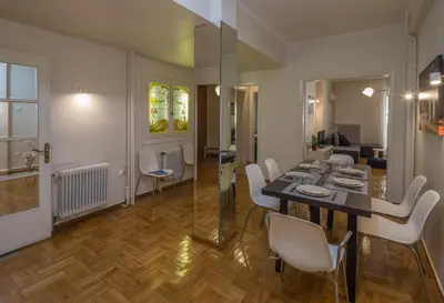 a dining room and living room with a table and chairs at Elite Downtown Central 5th Floor Apartment in Athens