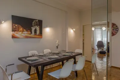 a dining room with a table and white chairs at Elite Downtown Central 5th Floor Apartment in Athens