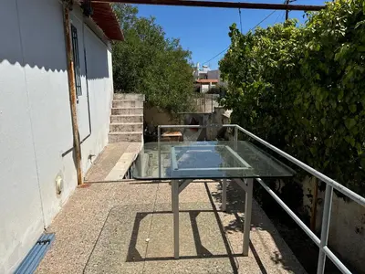 a glass table on top of a balcony at Surfers' Cottage in Anavissos
