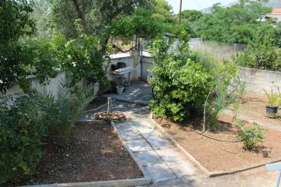 a garden with a fence and some bushes at Surfers' Cottage in Anavissos