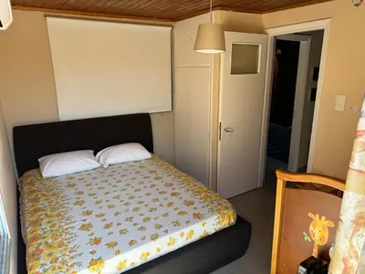 a bedroom with a bed and a door to a hallway at Surfers' Cottage in Anavissos
