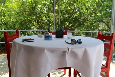 a white table with a pair of glasses on it at Surfers' Cottage in Anavissos