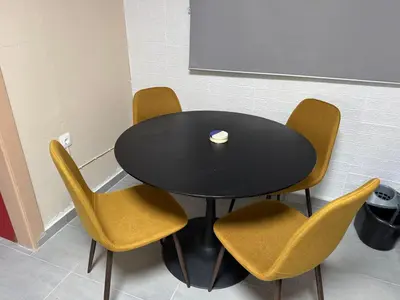 a black table with yellow chairs and a cup on it at Surfers' Cottage in Anavissos