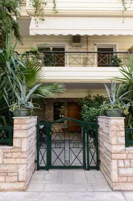 a green gate in front of a house with plants at Apartment & Parking 100m Kerameikos Metro in Athens