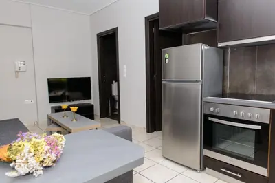 a kitchen with a stainless steel refrigerator and a table at Apartment & Parking 100m Kerameikos Metro in Athens