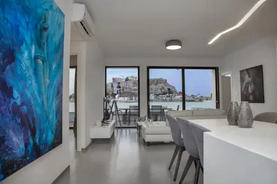 a living room with a large painting on the wall at Luxury Penthouse touching the Acropolis by GHH in Athens