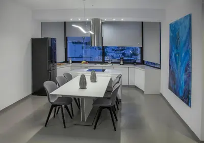 a kitchen with a white table and chairs in it at Luxury Penthouse touching the Acropolis by GHH in Athens