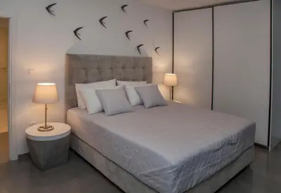 a bedroom with a large bed with two lamps at Luxury Penthouse touching the Acropolis by GHH in Athens