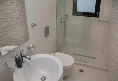 a white bathroom with a toilet and a sink at Luxury Penthouse touching the Acropolis by GHH in Athens
