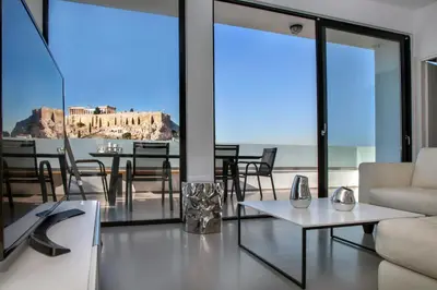 a living room with a couch and a table at Luxury Penthouse touching the Acropolis by GHH in Athens
