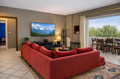 a living room with a red couch and a table at Cosy Relaxing Flat 60'' from Metro Station in Athens