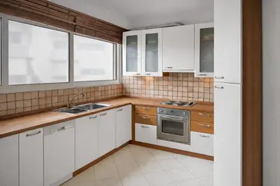 a kitchen with white cabinets and a sink and a stove at Cosy Relaxing Flat 60'' from Metro Station in Athens