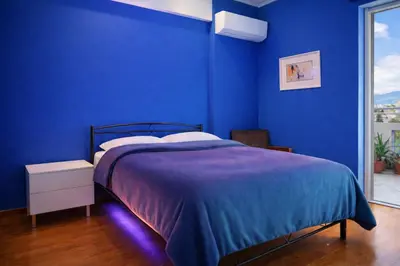 a blue bedroom with a bed with a blue wall at Cosy Relaxing Flat 60'' from Metro Station in Athens
