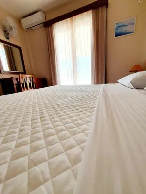 a large white bed in a room with a window at Acqua Marina - Άκουα Μαρίνα in Agia Marina Aegina