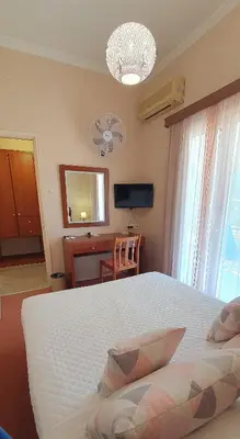 a bedroom with a bed and a desk and a television at Acqua Marina - Άκουα Μαρίνα in Agia Marina Aegina