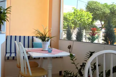 a small table and chairs in a room with a window at Acqua Marina - Άκουα Μαρίνα in Agia Marina Aegina