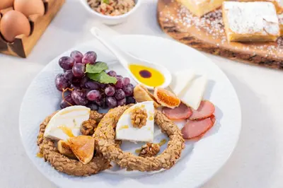 a plate of food with cheese and fruit on a table at Acropolis View Hotel in Athens