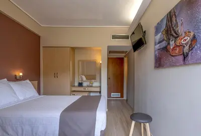 a hotel room with a bed and a tv on a wall at Acropolis View Hotel in Athens