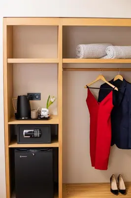 a closet with a shelf with a red dress and a printer at Acropolis View Hotel in Athens