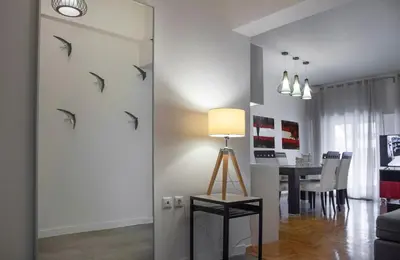 a living room with a table with a lamp and birds on the wall at Exceptional Penthouse close to Acropolis Museum by GHH in Athens