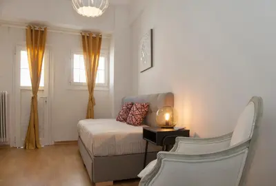 a small bedroom with a bed and a chair at Exceptional Penthouse close to Acropolis Museum by GHH in Athens