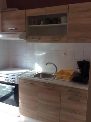 a kitchen with wooden cabinets and a sink at Sunny apartment in Athens