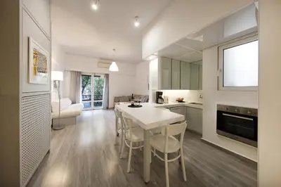 a kitchen and dining room with a white table and chairs at Artistic apartment next to everything in Athens