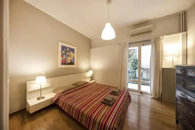 a bedroom with a bed and a dresser and a window at Artistic apartment next to everything in Athens