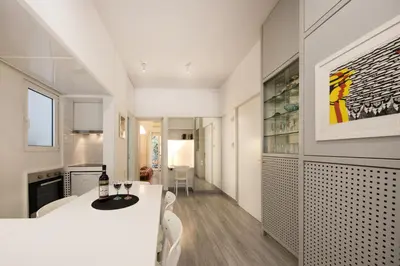 a white kitchen and dining room with a table and chairs at Artistic apartment next to everything in Athens