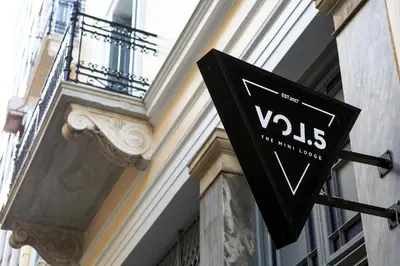 a black sign on the side of a building at Vol.5 in Athens