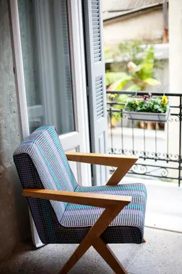 a chair sitting on a porch next to a window at Vol.5 in Athens