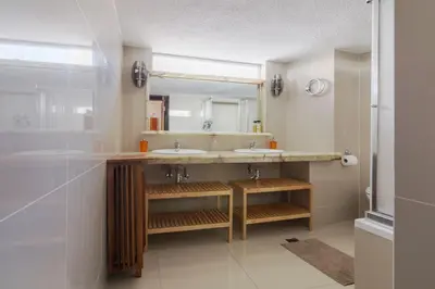 a bathroom with two sinks and a large mirror at Acropolis View apartment 120sqm in Athens
