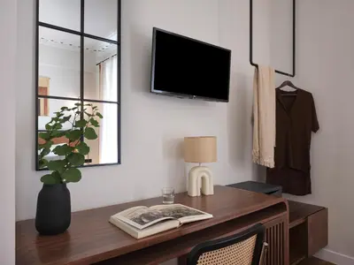 a room with a desk with a tv on a wall at Astikon House in Athens