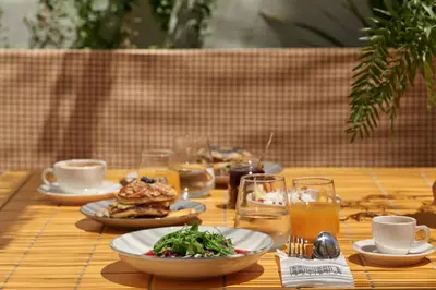 a wooden table with plates of food and drinks at Astikon House in Athens
